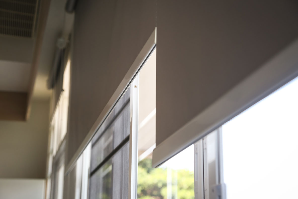 Details of white fabric roller blinds on the plastic window in the living room