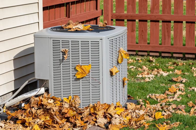 Dirty air conditioning unit covered in leaves during autumn, How To Clean An Armstrong Air Conditioner