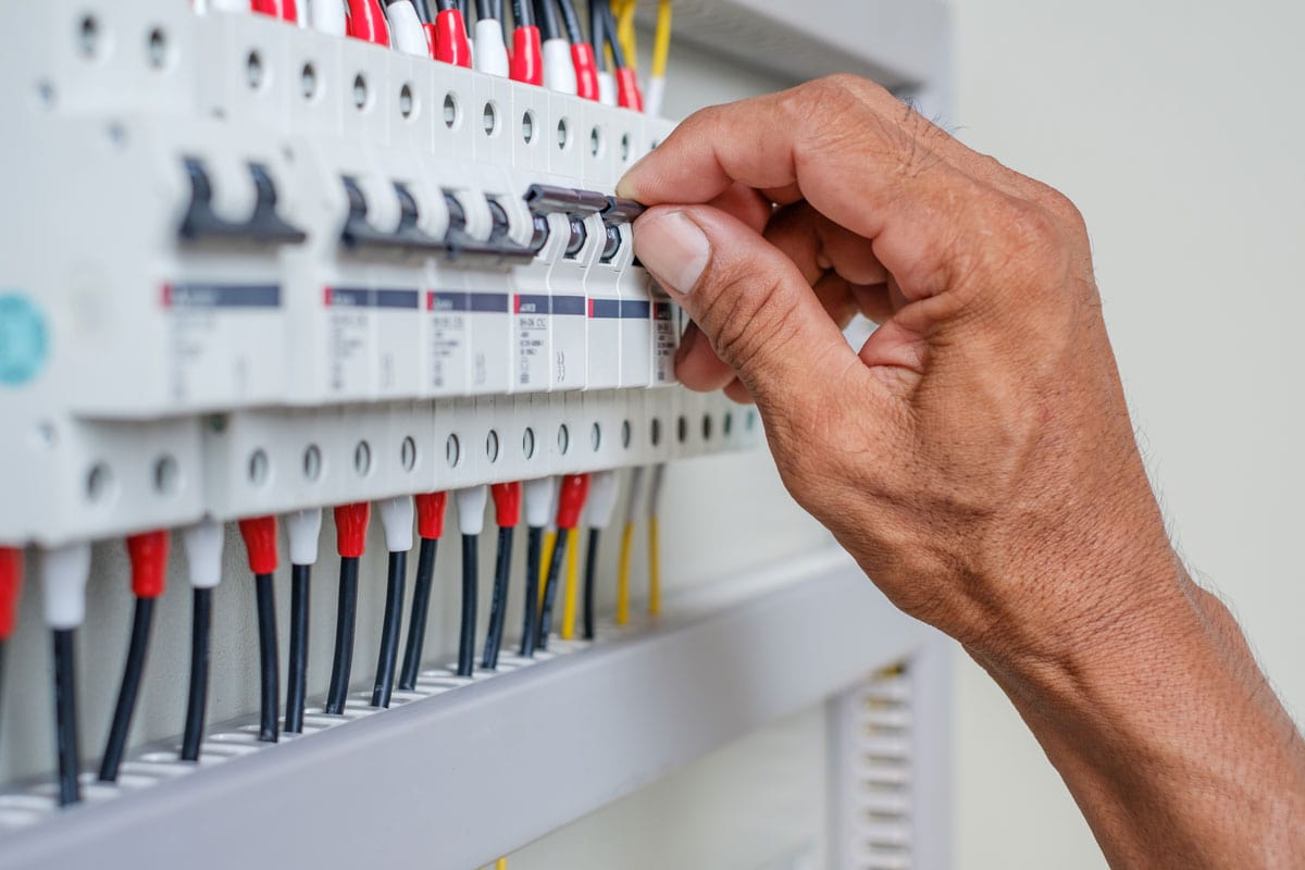 Electrician turning a circuit breaker