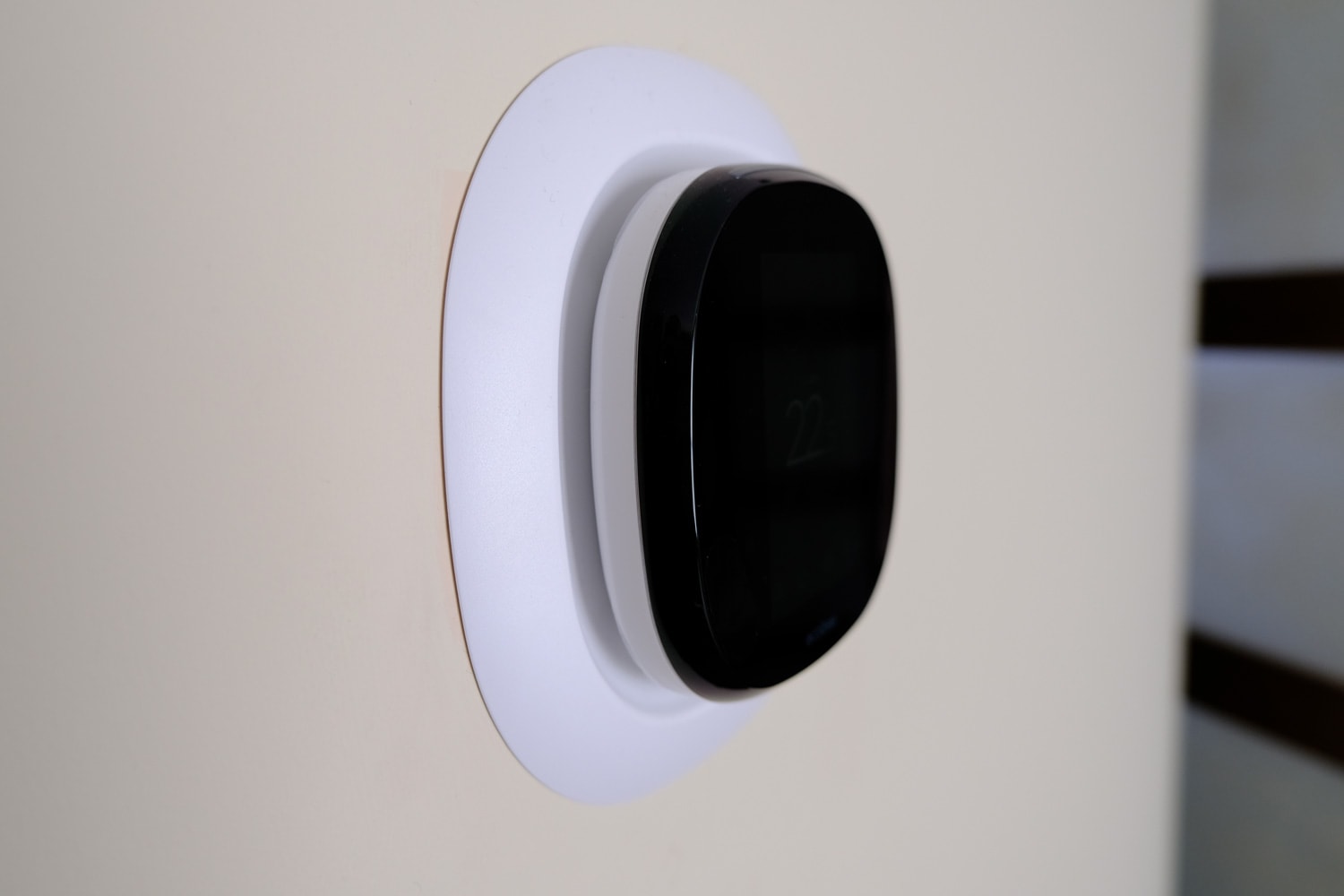 Energy-saving thermostat for temperature control. Modern design, ecobee style installed on the wall. Green energy.
