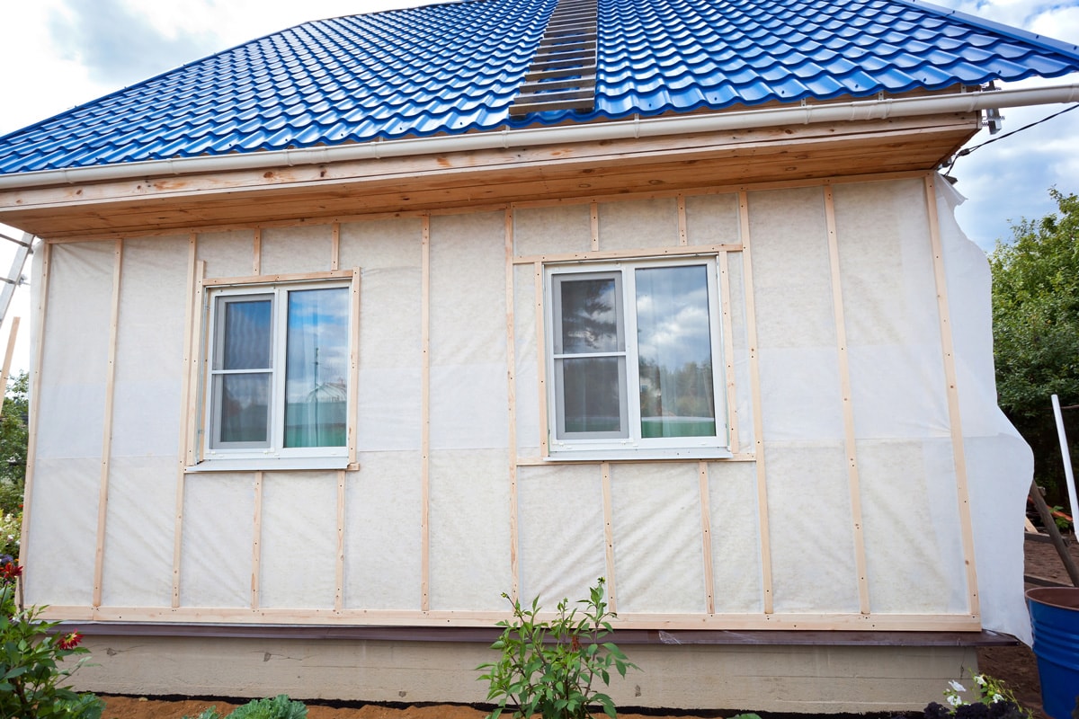 External wall insulation in wooden house, building under construction