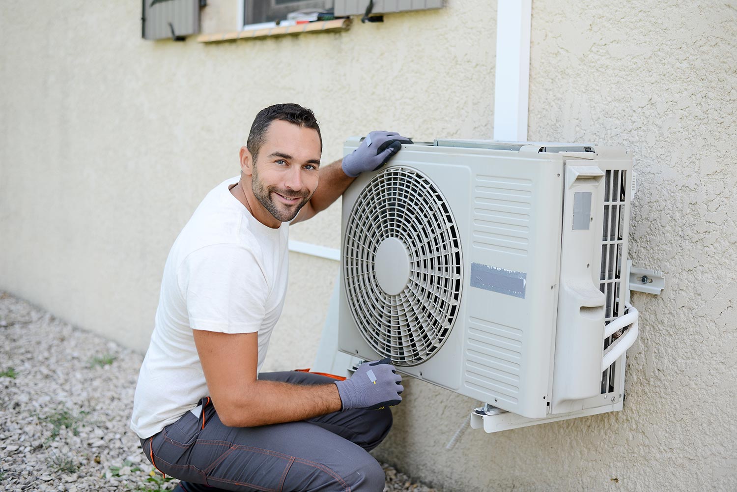 Handsome young man electrician installing an air conditioning