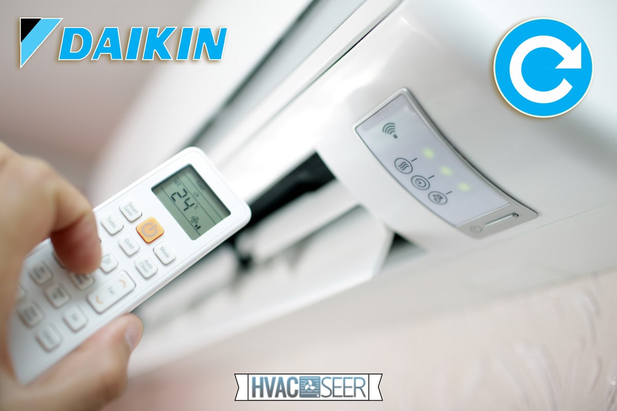 A man holding a remote pointing into a Daikin airconditioner, How To Reset A Daikin Air Conditioner
