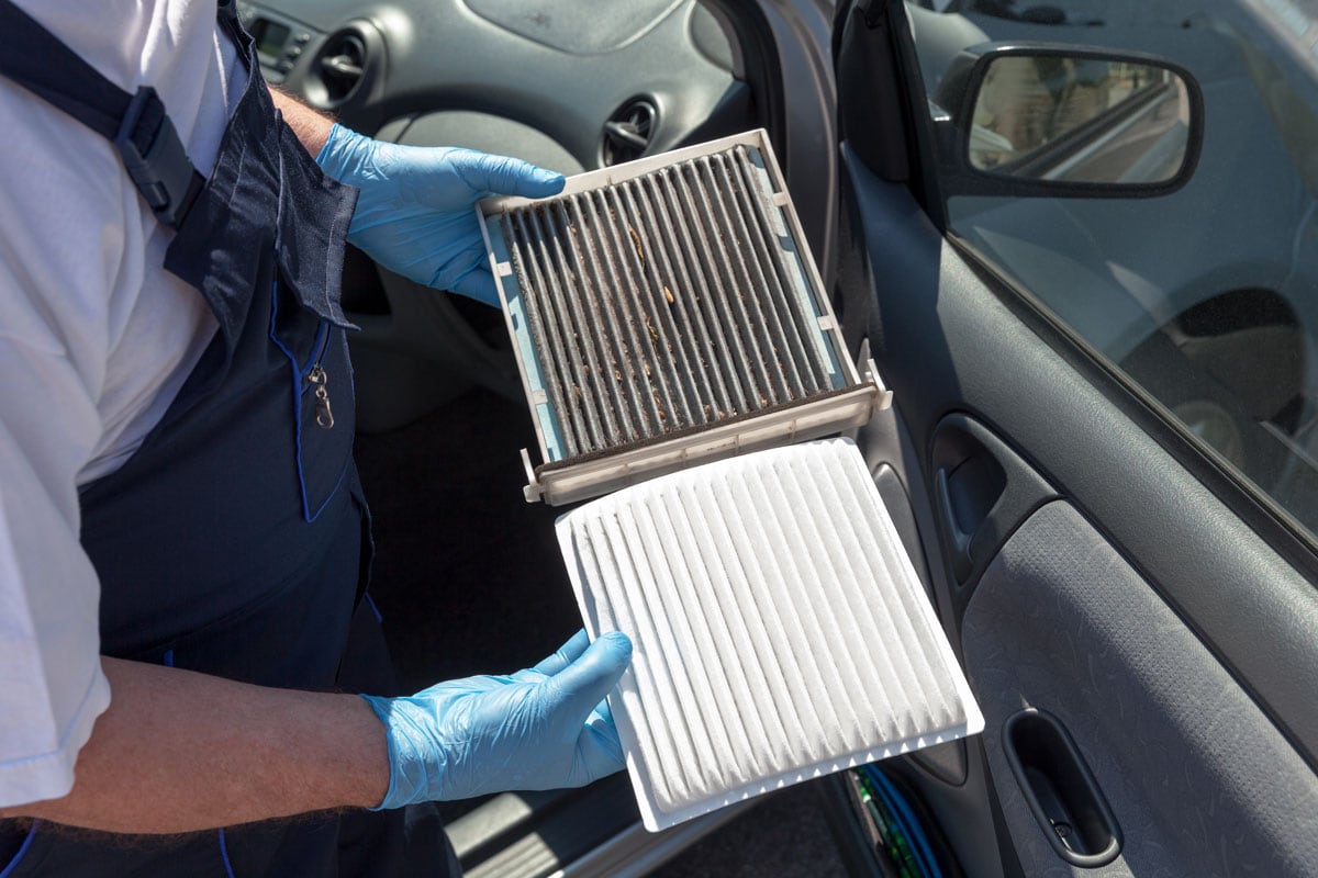 Mechanic changing the AC filter with a new one