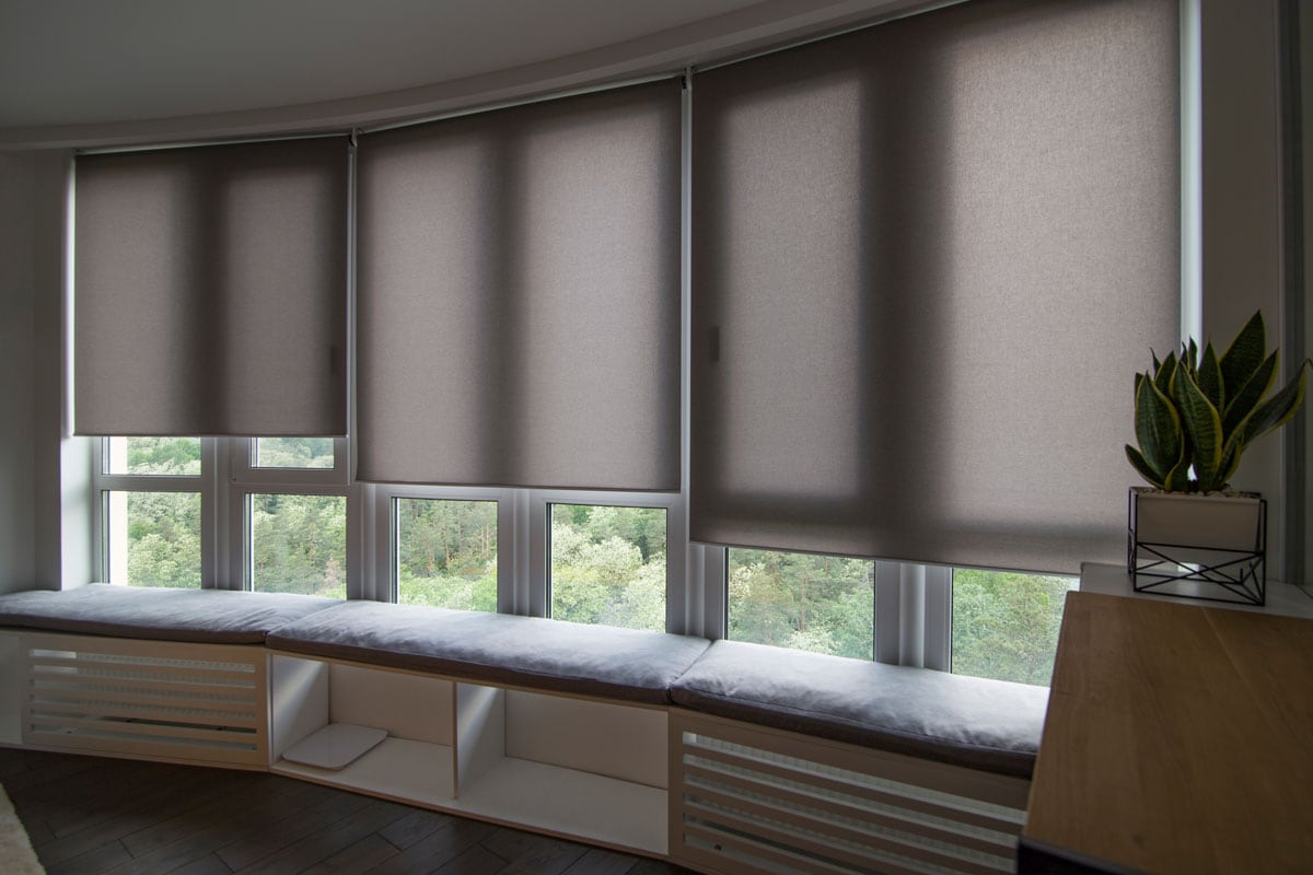 Motorized roller shades in the interior automatic roller blinds beige color on big glass windows