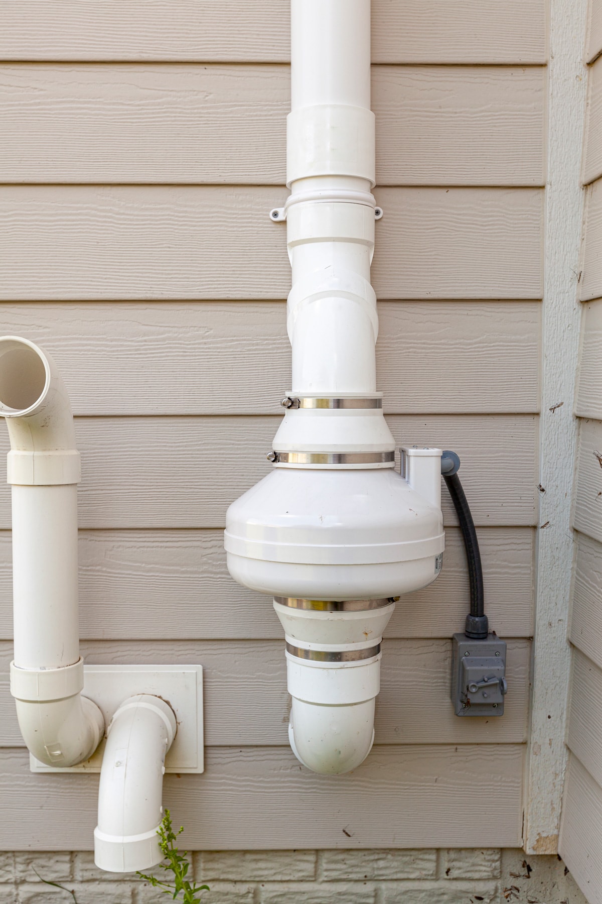 PVC pipes attached to the electrical motor of a residential radon mitigation system. 