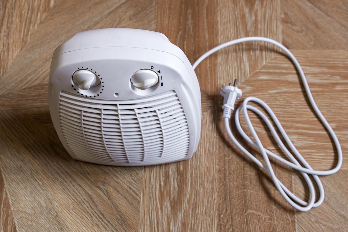 Portable electric fan heater on floor at home