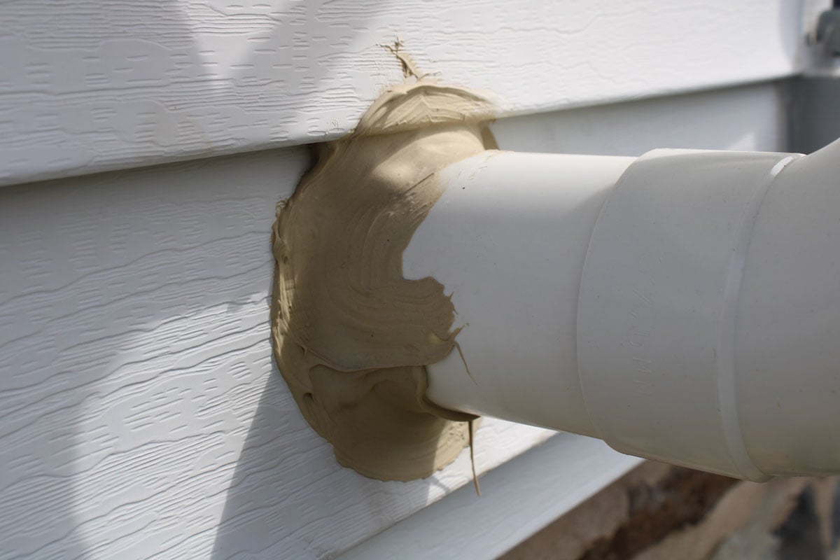 Radon vent pipe sealed with dark brown epoxy