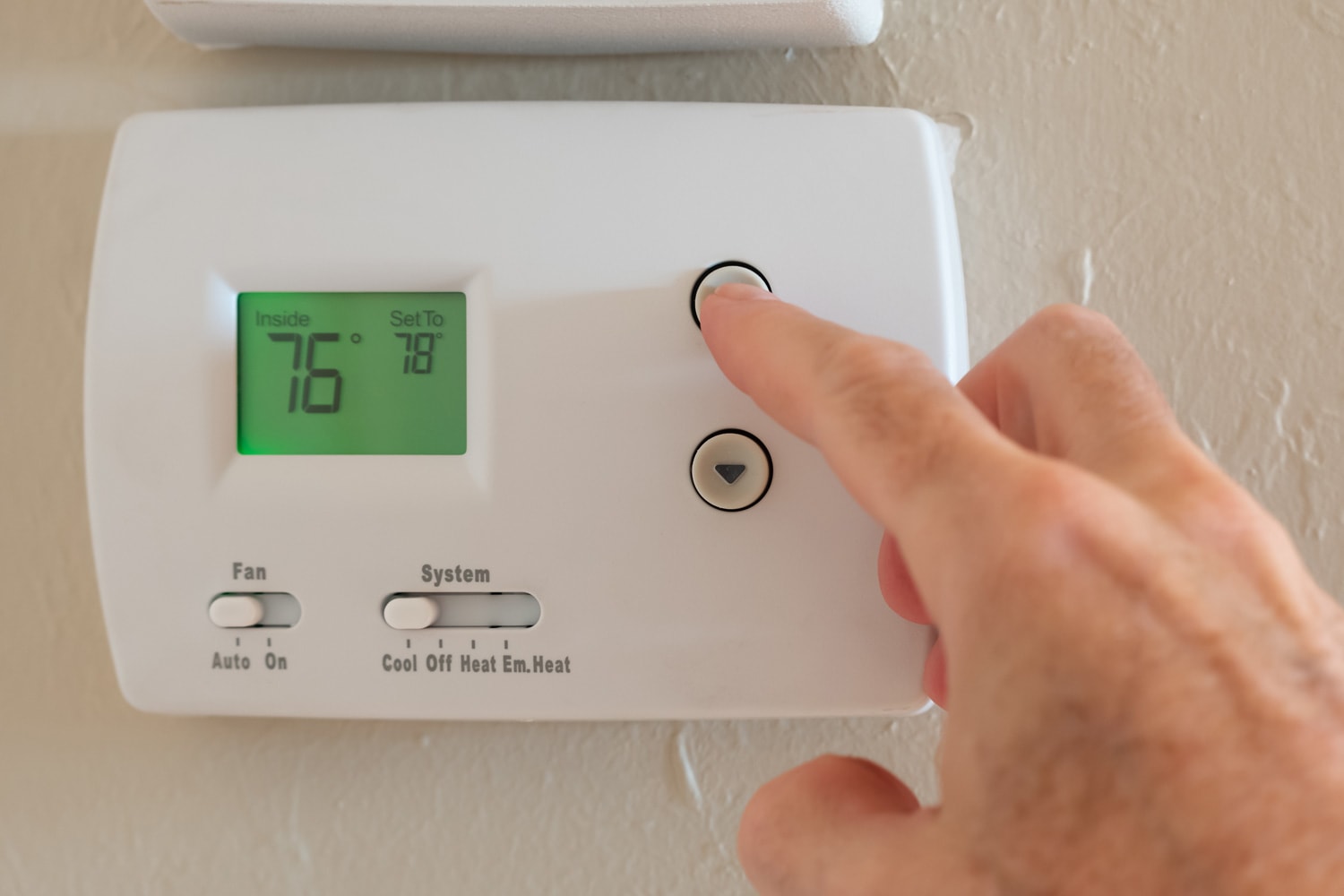 Setting digital thermostat to cool and programming air conditioning to energy saving temperature of 78 degrees.