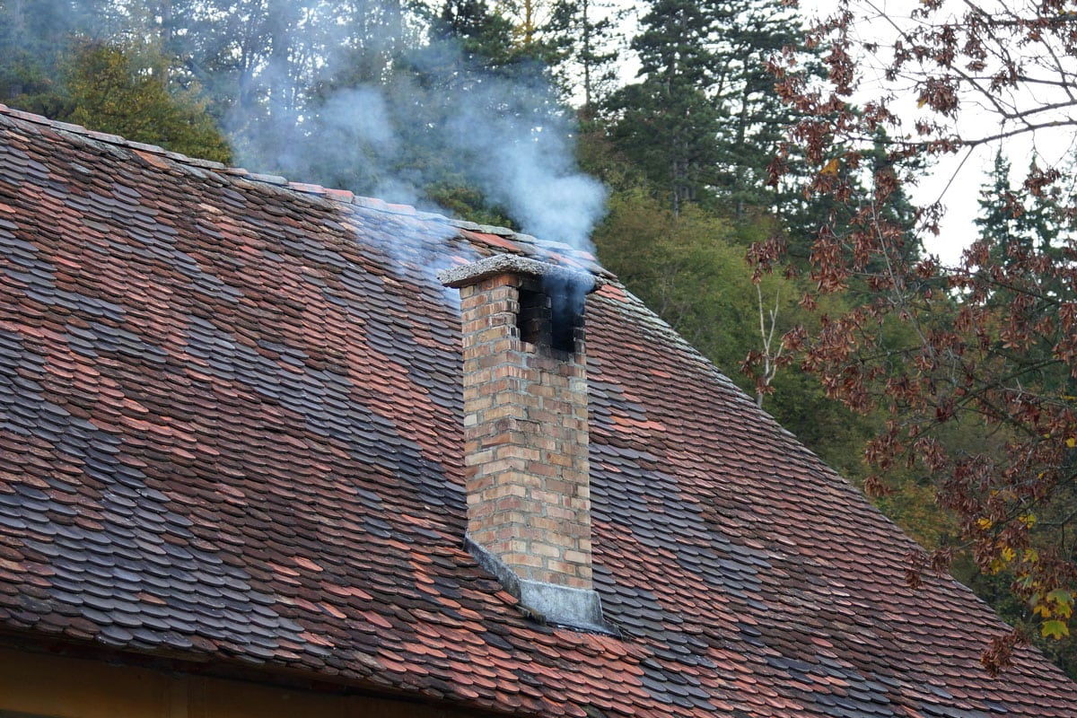Smoke from the chimney of old house