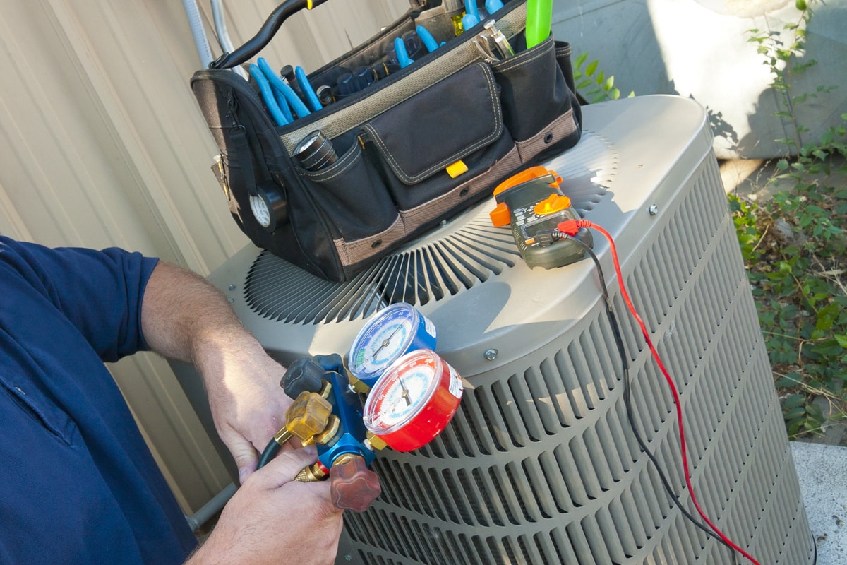 Specialist using a testing equipment for an air conditioning unit