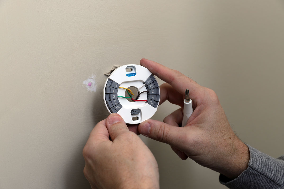 Technician installing a brand new thermostat
