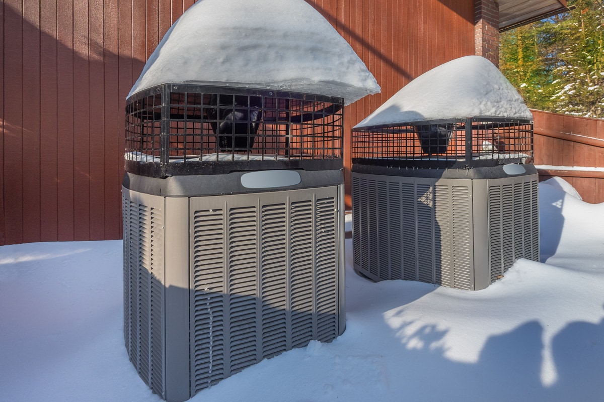 Two air conditioning units with mesh covers to protect it from snow