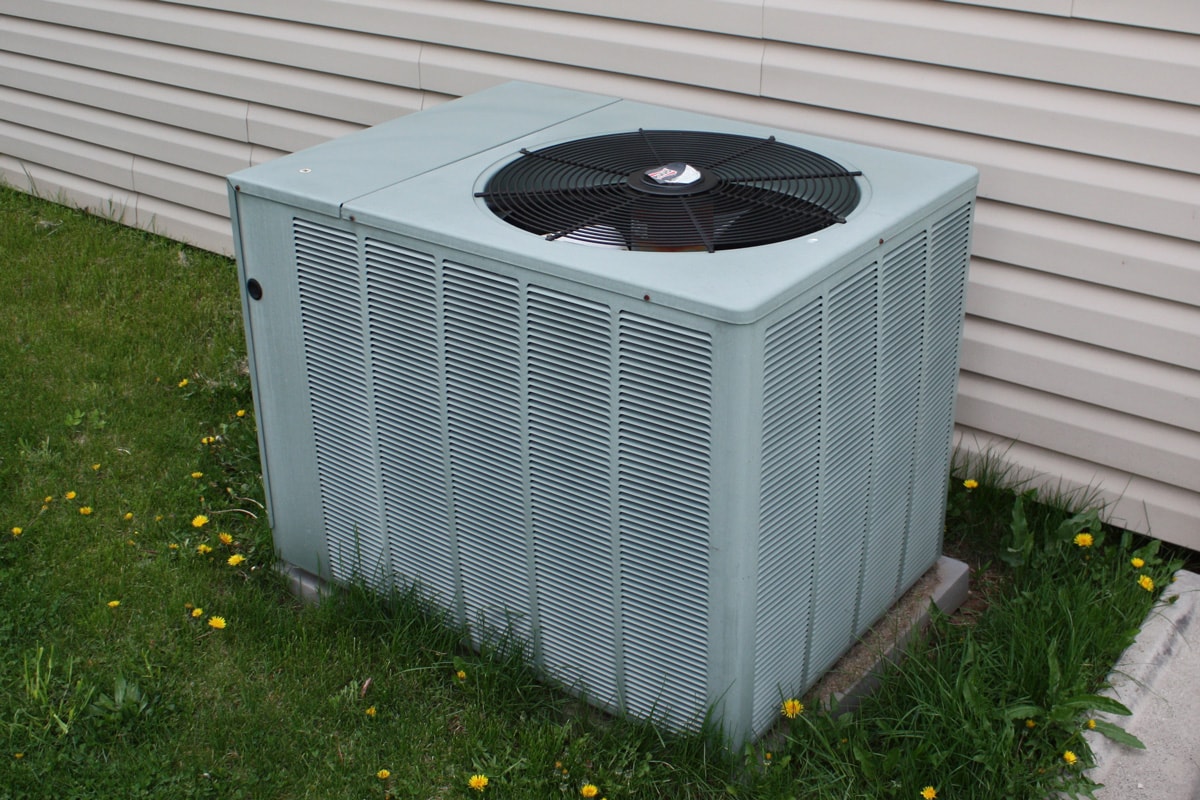 White air conditioning unit mounted on a concrete slab