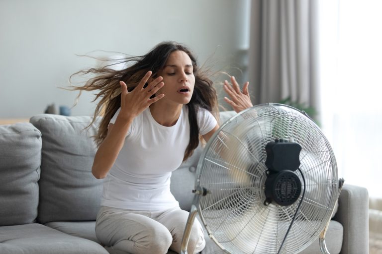 Woman turned on fan waving her hands to cool herself - Why Is My House Hotter Than Outside