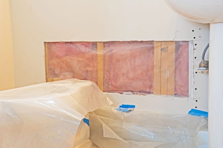 a hole in the drywall has been prepared for patching and a sheet of plastic placed over the insulation to act as a vapor barrier., How To Repair Vapor Barrier Behind Drywall?