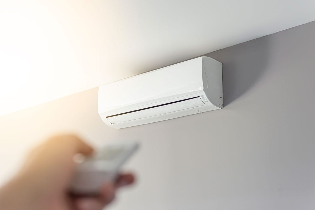 A man shutting down the air conditioner with remote control, Is Dry Mode More Economical?