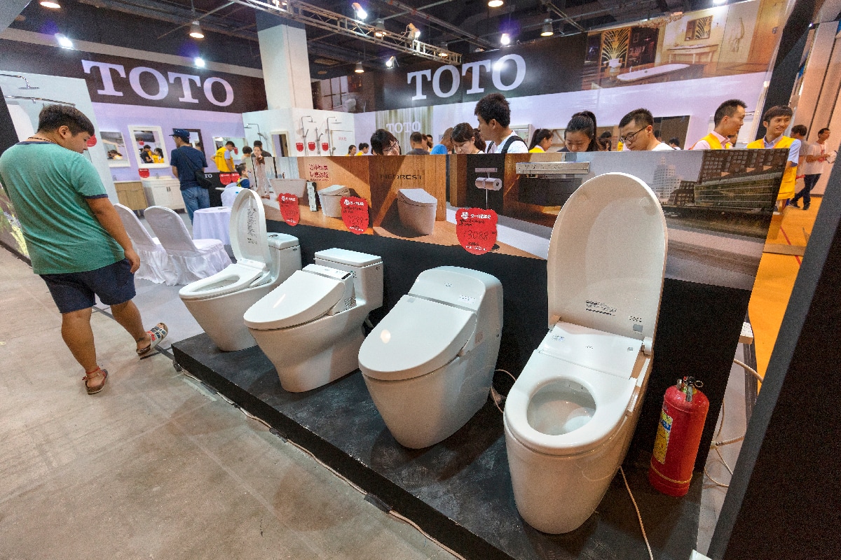 A visitor takes a look of TOTO washlets at the TOTO booth