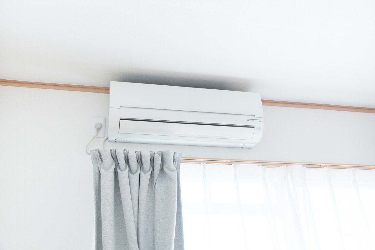 A white colored mini split ac system mounted on a wall