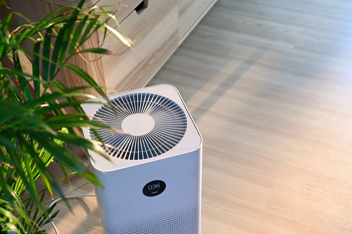 Air purifier on wooden floor in comfortable home. Fresh air and healthy life.