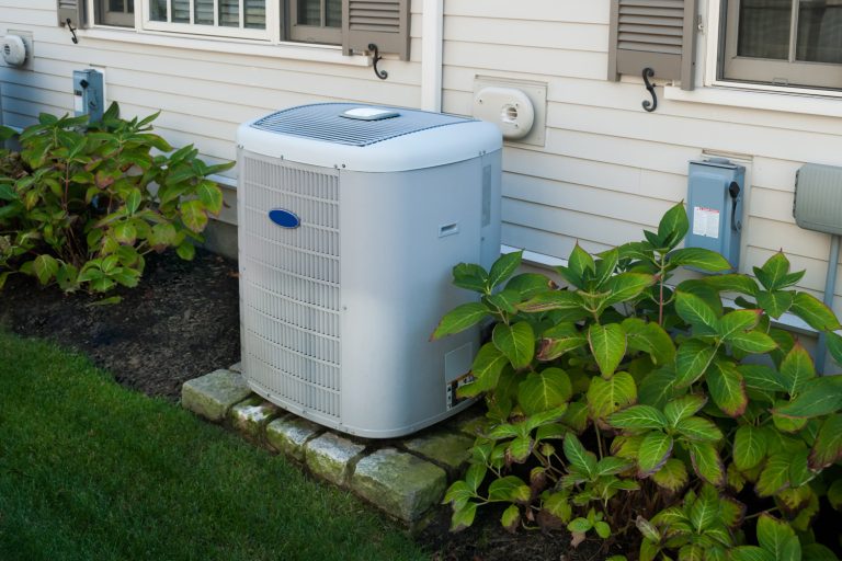 Carrier Heating and air conditioning inverter on the side of a house - Carrier Vs York Which HVAC Brand To Choose