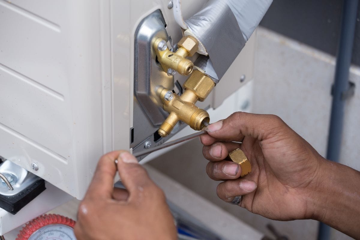 Installation of air conditioner, worker open drip valve — Photo