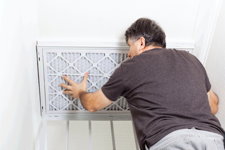 Man replacing a filter on a home air conditioning system. Is It Better To Have A Dirty Air Filter Or No Air Filter In HVAC