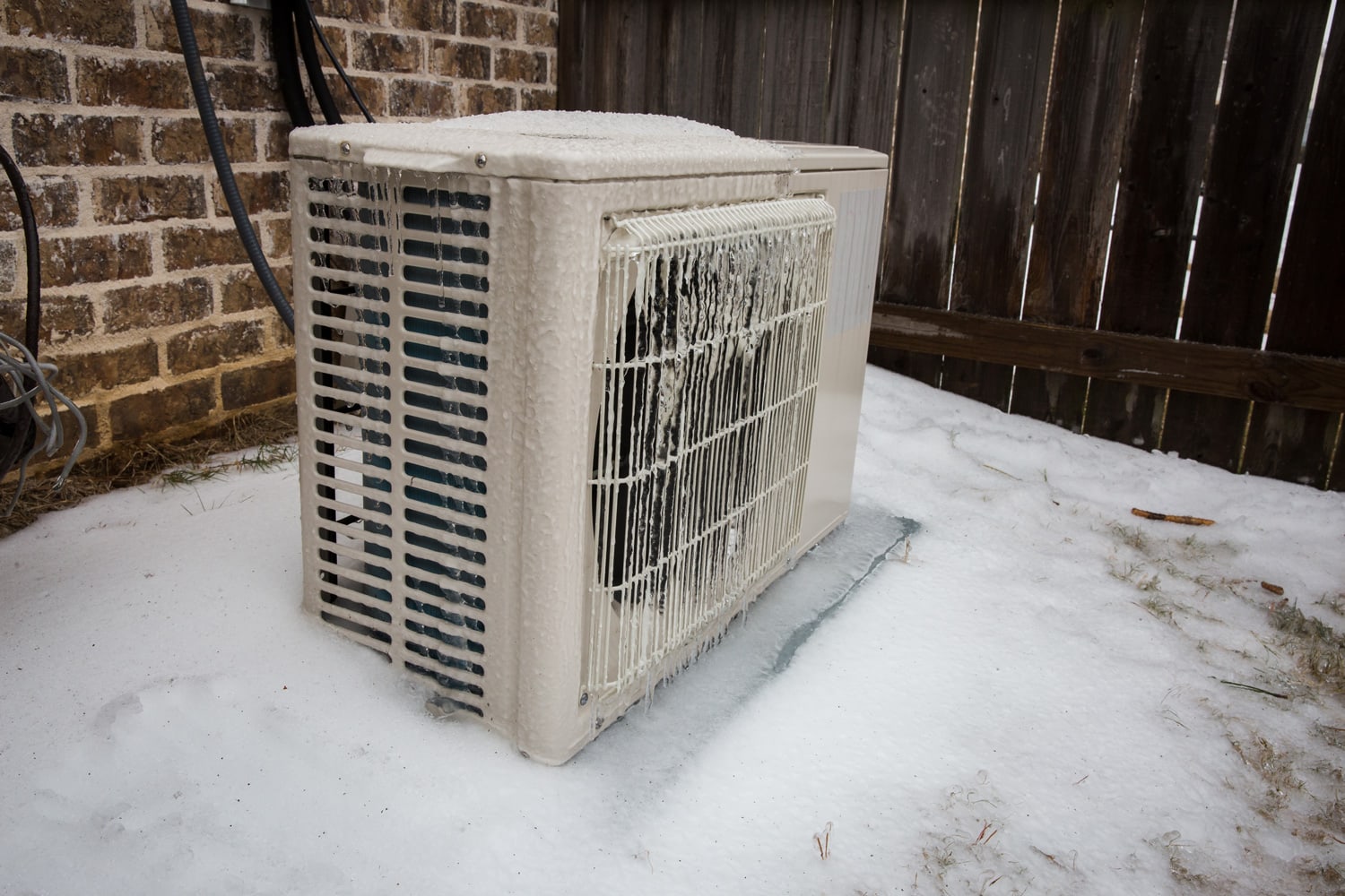 Mini split air conditioning outdoor unit covered in ice from winter storm