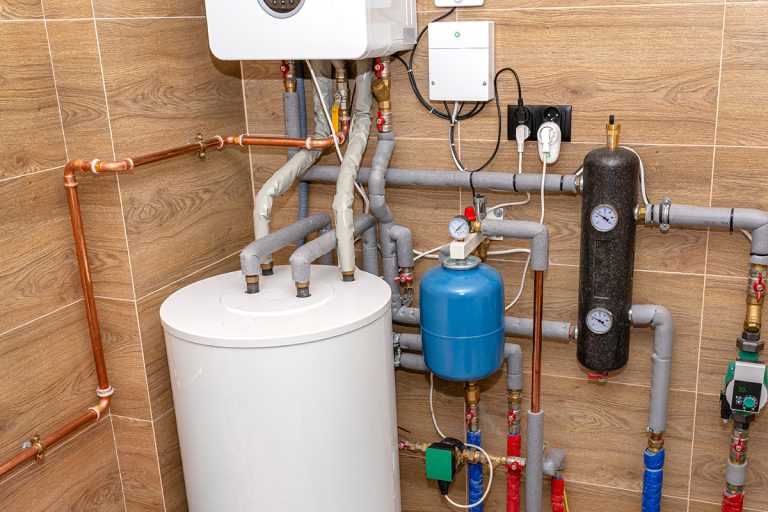 A modern gas boiler installed in a boiler room lined with ceramic tiles, What Causes Too Much Pressure In Hot Water Heater?