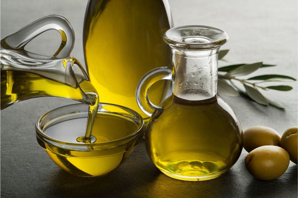 Organic olive oil. Bottle of Extra virgin oil pouring in to glass bowl
