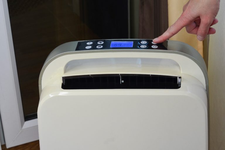 A person pressing the button of a portable air conditioner unit, How To Reset A Danby Air Conditioner
