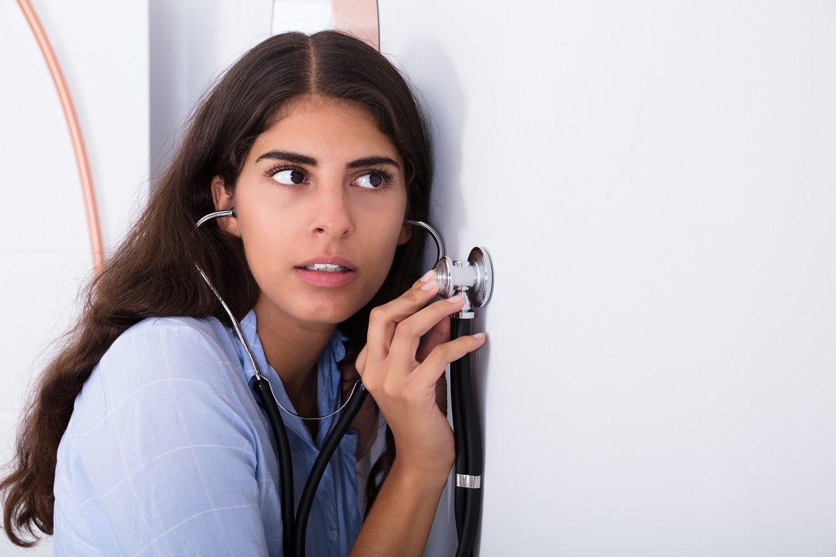 Young,Curious,Women,Listening,Through,Wall,Using,Stethoscope