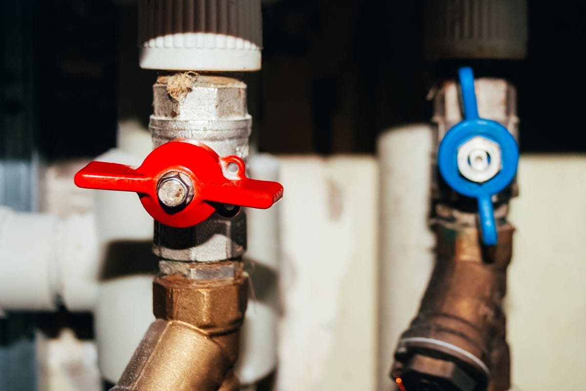 Two-valves-on-plastic-and-metal-pipes-with-hot-and-cold-water.-Open-blue-and-closed-red-switches.-Hot-water-is-turned-off.jpg