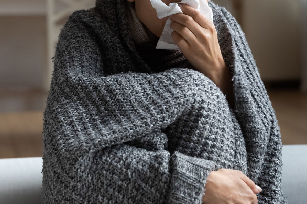 Unhealthy young woman suffering from runny nose