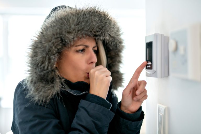 Woman With Warm Clothing Feeling The Cold Inside House - Should I Use Emergency Heat During An Ice Storm