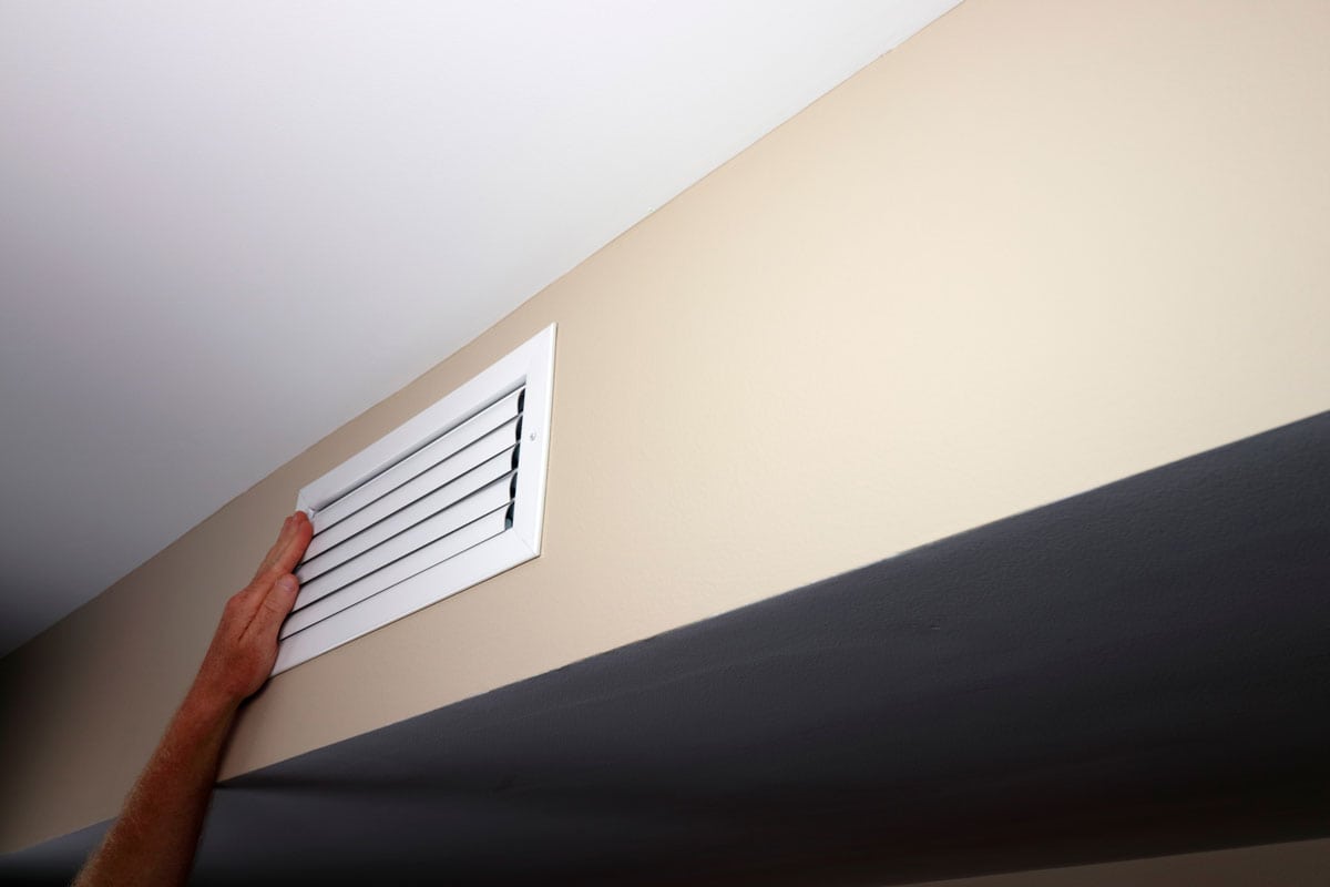 photo of a man hands checking the air flow coming from the air vents brand new air vents