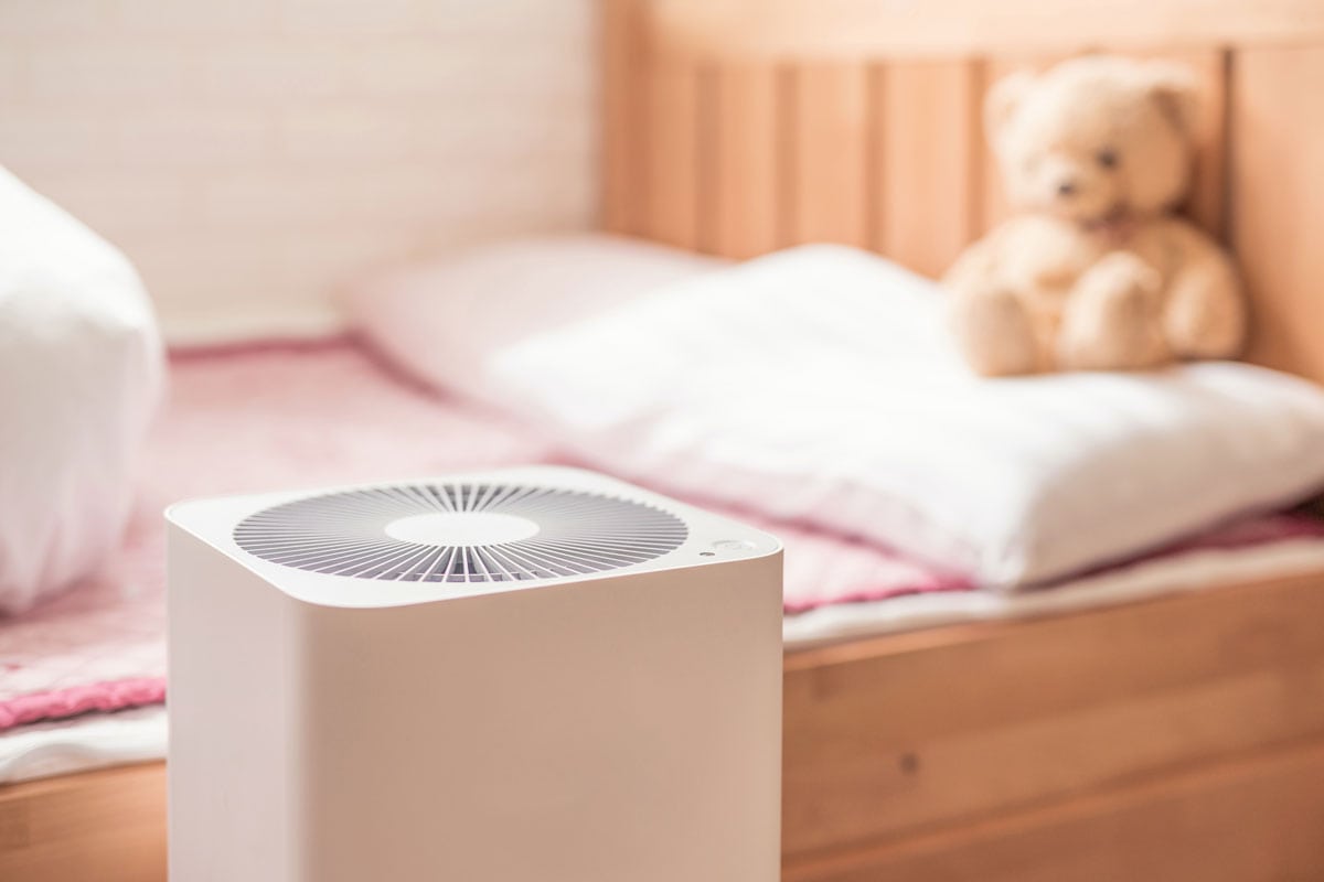 photo of a modern type air purifier inside the children bedroom beside the bed