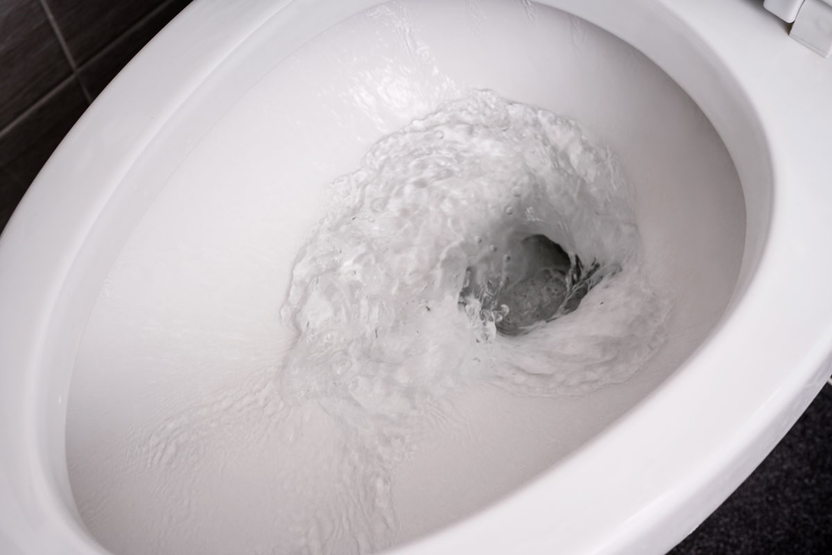 photo of a toilet flushing water cleaning toilet white toilet