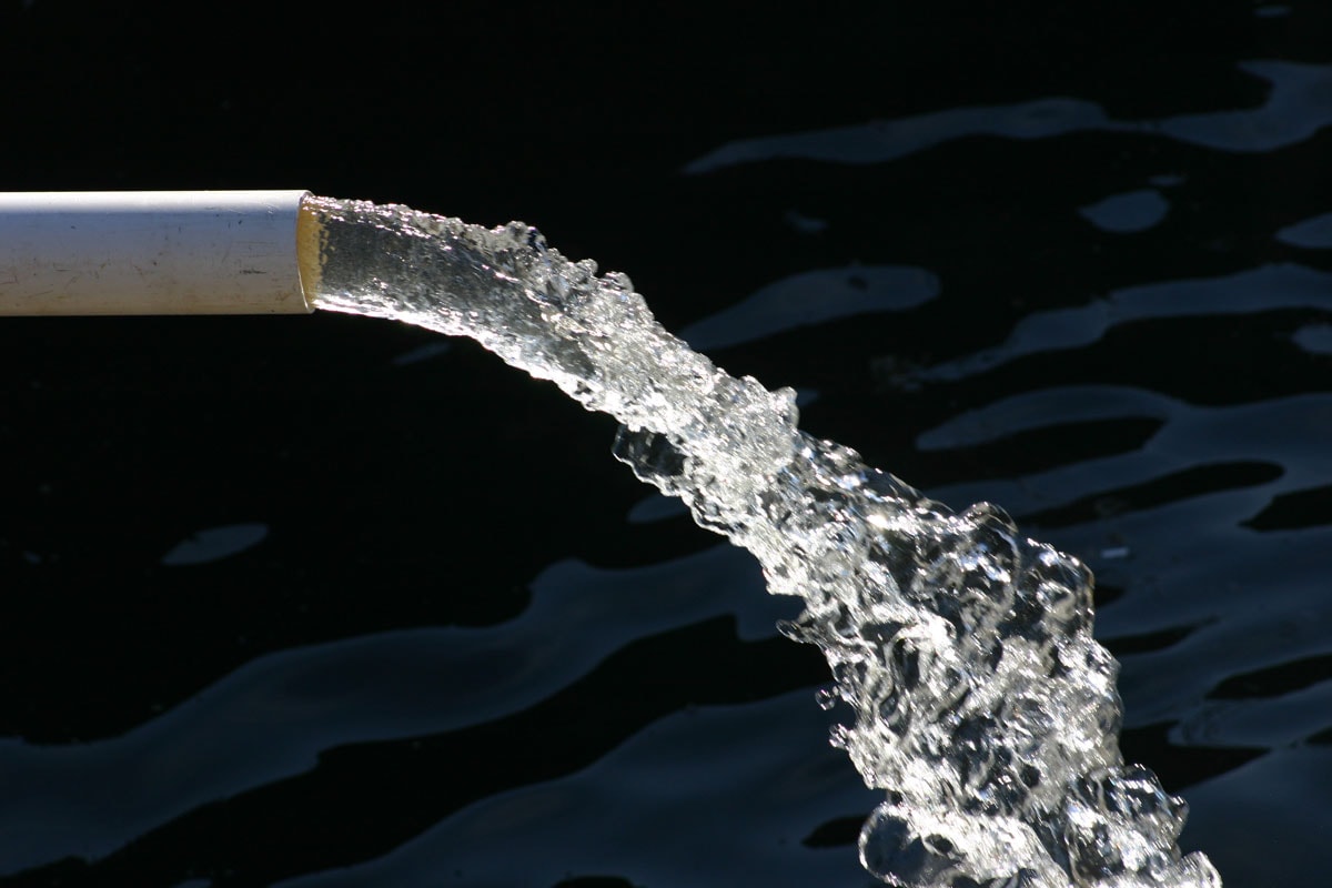 photo of a water flows comes from the white pvc pipe on the construction
