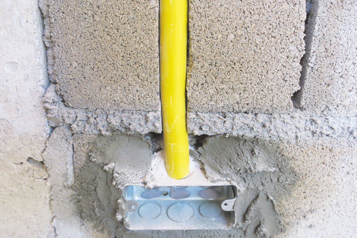 photo of a yellow plastic pvc pipe inside building wall