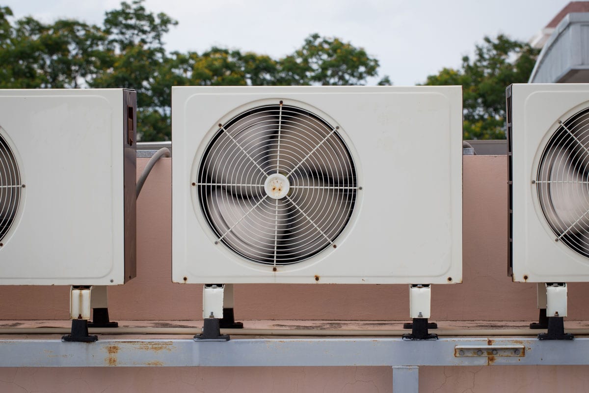 photo of three aircon aligned on top of a house roof roof top