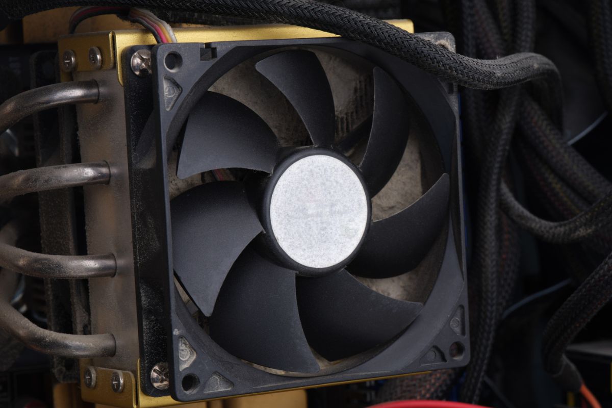 A dusty CPU fan in a computer case. Close up.