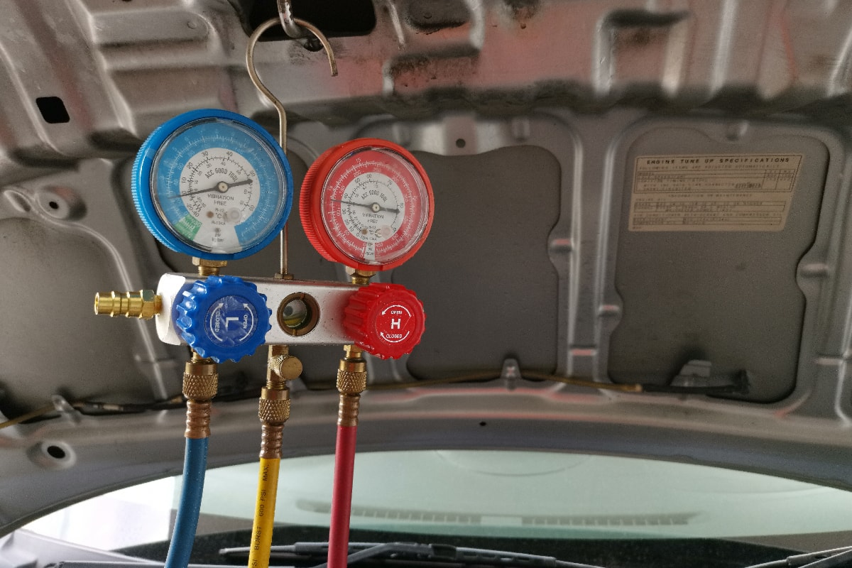 Air conditioning pressure manifold gauge set hanging by the car