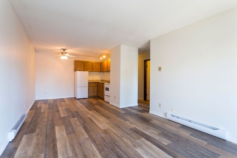 An empty vacant rental apartment property with new hardwood laminate floors and white paint on the walls, When To Bleed Baseboard Heaters?