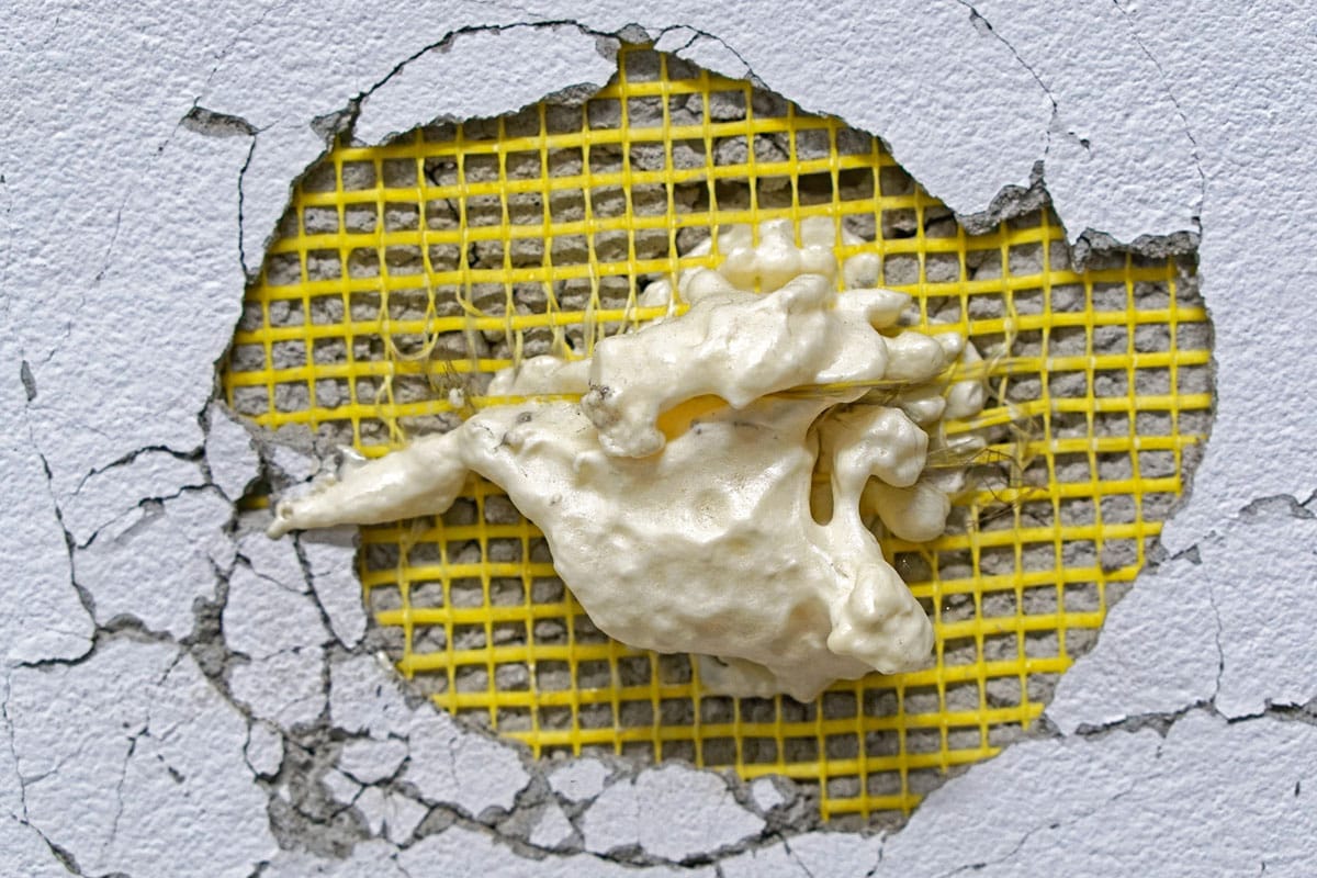 Big hole in wall with expanded foam repair try