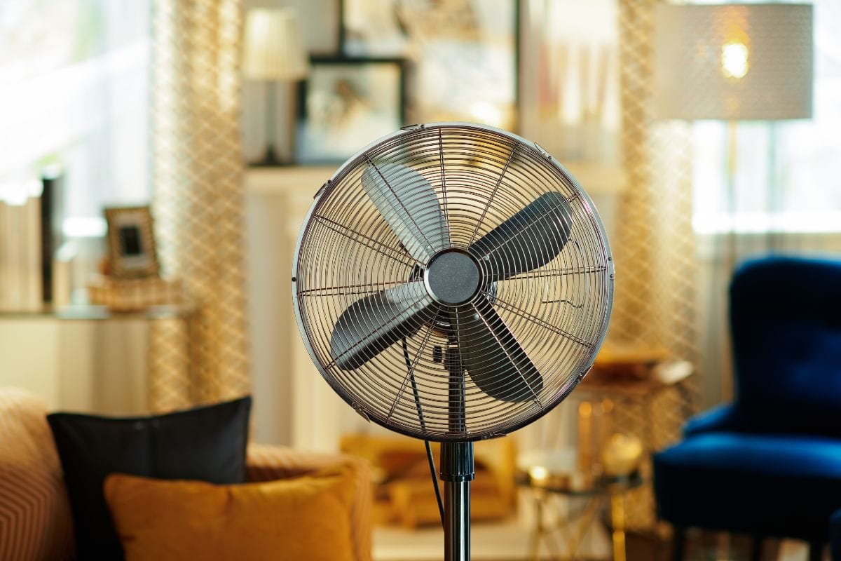 Closeup on electric floor standing fan in the modern living room in sunny hot summer day.