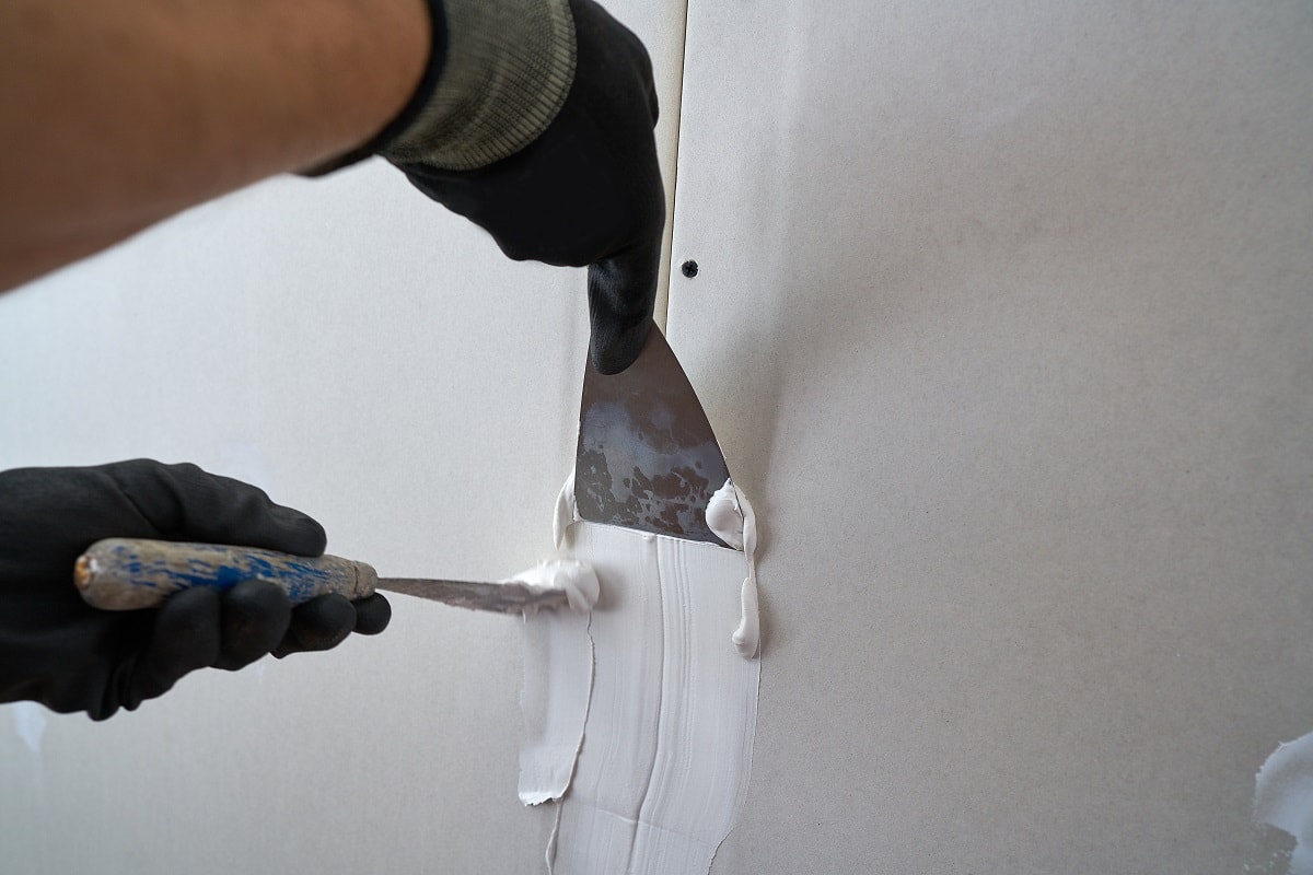 Dot and dab the adhesive - Laminate plaster plate plaster joins hands with detail spatula