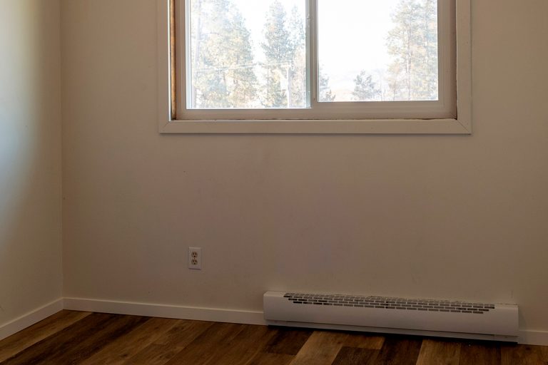 Empty vacant rental apartment property with new hardwood laminate floors and baseboard heater, Does A Baseboard Heater Need A Thermostat?