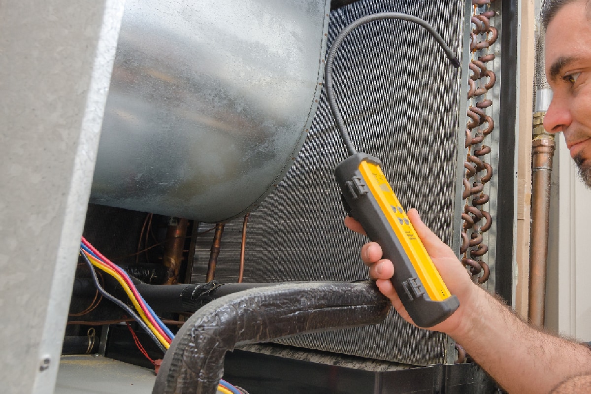 HVAC technician with leak detector