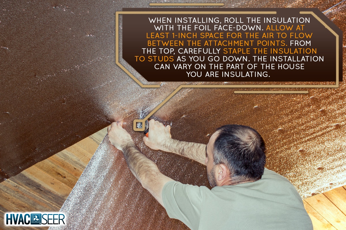 A builder attaches the insulation to the ceiling, How To Install Reflective Roll Insulation